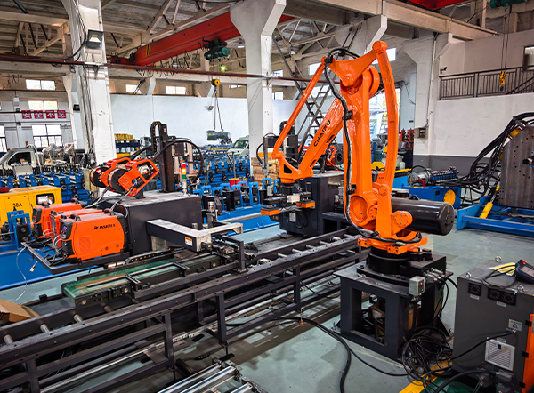 Robotic welding and stacking station featuring industrial robot arm and welding power sources